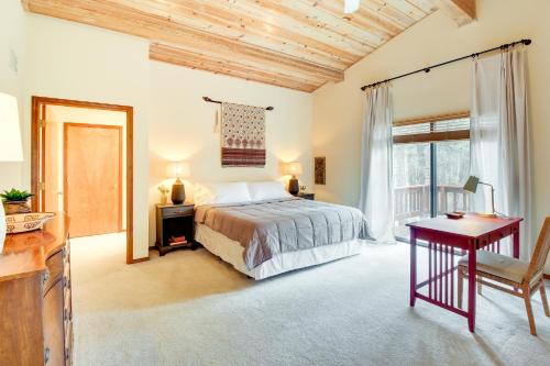 Schlafzimmer mit einem Bett, einem Schreibtisch und einem Fenster in der Unterkunft Spacious Pinetop-Lakeside Home with Deck - Near Golf in Pinetop-Lakeside