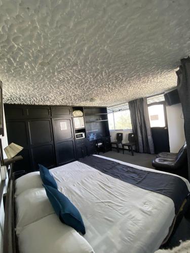 a bedroom with a large bed with blue pillows at Hotel Andenes in Arequipa