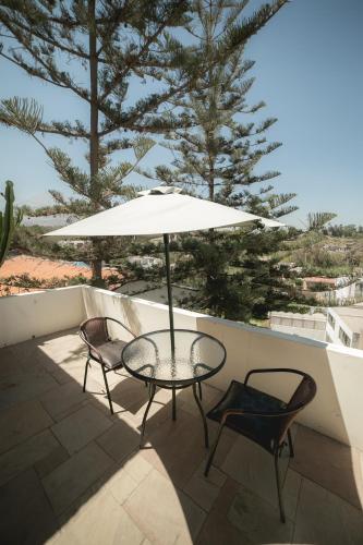 a patio with a table and two chairs and an umbrella at Hotel Andenes in Arequipa