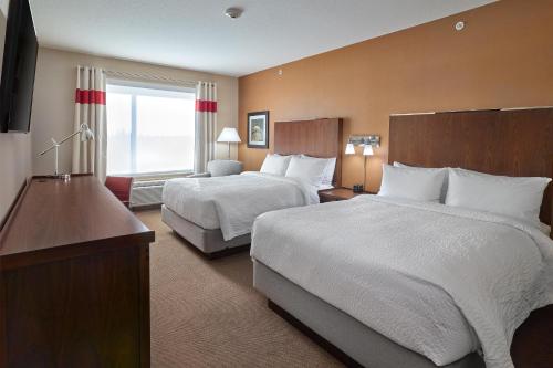 a hotel room with two beds and a large window at Four Points by Sheraton Edmonton West in Edmonton