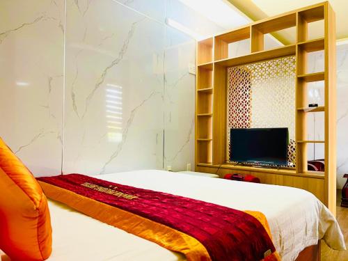 Quảng Trị的住宿－Khách sạn Khánh Phương，一间卧室配有一张床和一台平面电视