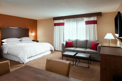 a hotel room with a bed and a couch at Four Points by Sheraton Edmundston Hotel & Conference Center in Edmundston