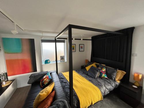 a bedroom with a bed with a black canopy at The Studio by Hip Haus in Cleethorpes