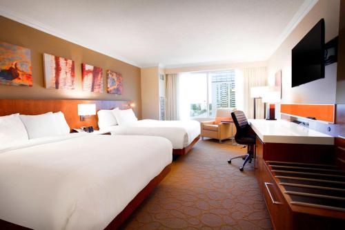 a hotel room with two beds and a desk at Delta Hotels by Marriott London Armouries in London
