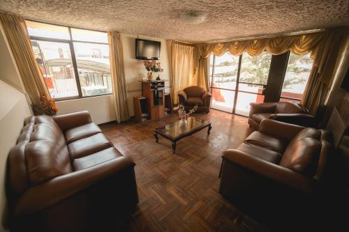 sala de estar con sofás de cuero y mesa de centro en Hotel Andenes, en Arequipa