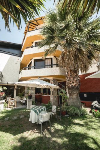 a table and chairs and a palm tree in front of a building at Hotel Andenes in Arequipa