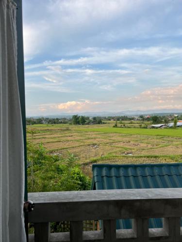 a view of a field from a window at โรงแรมมีวาสนา - Me Vadsana Hotel in Ban Thung Yao