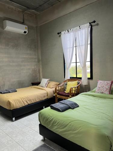 a room with three beds and a window at โรงแรมมีวาสนา - Me Vadsana Hotel in Ban Thung Yao