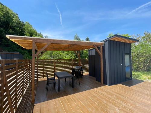 a deck with a table and chairs and a shed at Ｋ&Ｂグランピング　天空の城 in Takeda