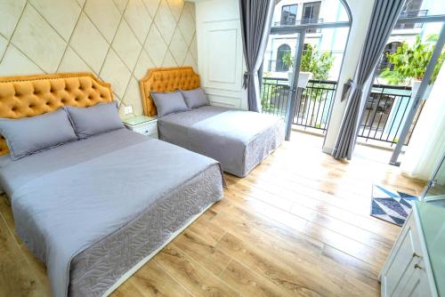 1 dormitorio con 2 camas y balcón en Ánh Dương Villa Homestay Hạ Long 7 Phòng ngủ cách Bãi biển 200m en Ha Long