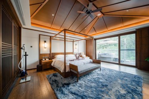 1 dormitorio con cama con dosel y ventana grande en G-Luxe by Gloria Taimei Suzhou, en Suzhou