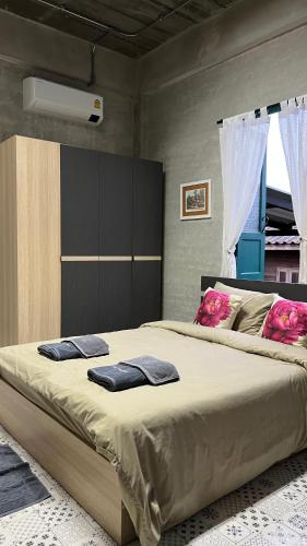 a bedroom with a large bed with pink pillows on it at โรงแรมมีวาสนา - Me Vadsana Hotel in Ban Thung Yao