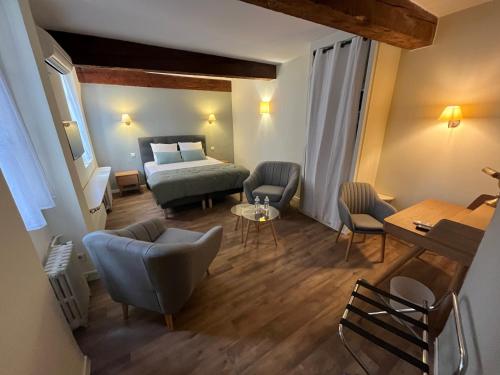 a hotel room with a bed and a table and chairs at Le Clos d'Orange, Hotel & ville de Provence in Orange