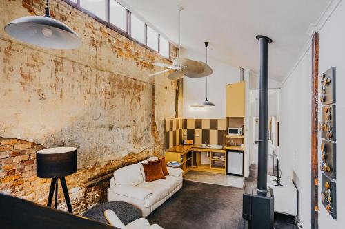 a living room with a couch and a brick wall at Albert Hotel Daylesford in Daylesford