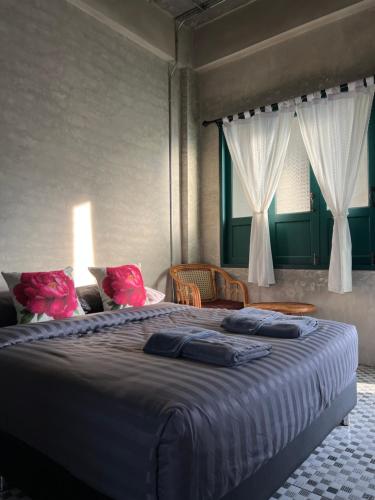 a bedroom with a large bed with two pillows on it at โรงแรมมีวาสนา - Me Vadsana Hotel in Ban Thung Yao