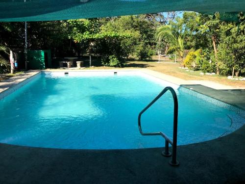 a large blue swimming pool with a hand rail in it at Casa vacacional Morales in Puntarenas