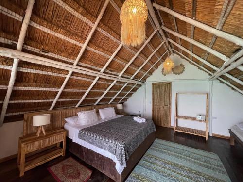 Schlafzimmer mit einem Bett und einem Kronleuchter in der Unterkunft NENA BEACH CLUB & HOTEL in Barú