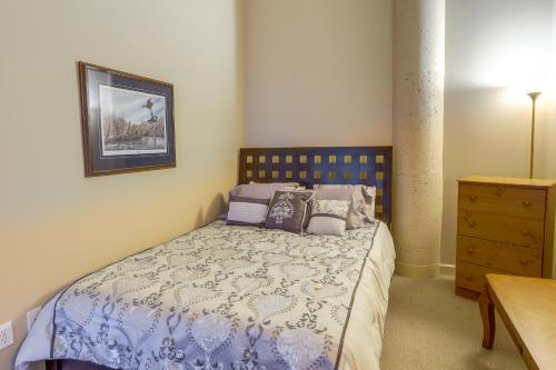 a bedroom with a bed with a blue comforter and pillows at Waterfront Sandusky Vacation Rental Downtown! in Sandusky