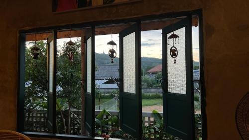 an open window with a view of a yard at โรงแรมมีวาสนา - Me Vadsana Hotel in Ban Thung Yao