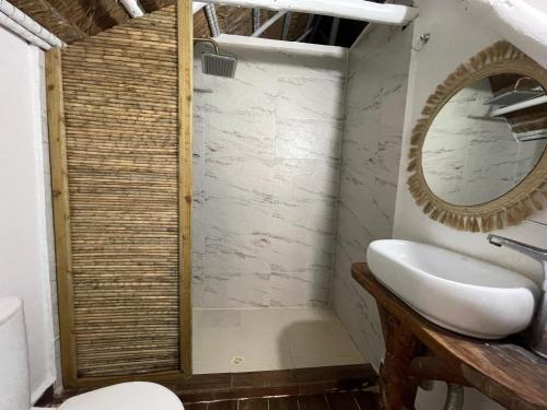 a bathroom with a sink and a mirror at NENA BEACH CLUB & HOTEL in Baru