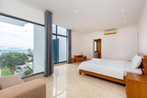 ein Schlafzimmer mit einem Bett und einem großen Fenster in der Unterkunft Ruby White Villa RL02 Sea View in Vũng Tàu