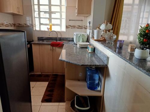 a kitchen with a granite counter top and a refrigerator at B’s homely in Ruiru