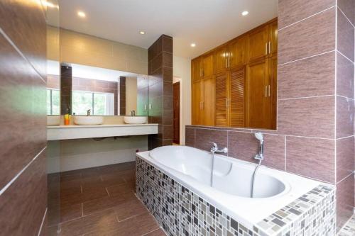 ein großes Bad mit einer Badewanne und 2 Waschbecken in der Unterkunft Ruby White Villa RL02 Sea View in Vũng Tàu