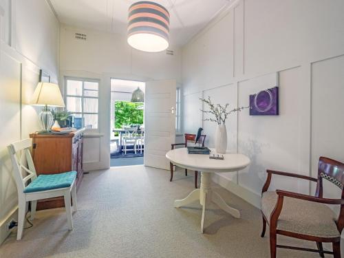 ein Wohnzimmer mit Tisch und Stühlen in der Unterkunft Leura Country Cottage in Leura