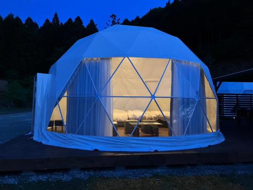 a blue tent with a bed in it at night at Ｋ&Ｂグランピング　天空の城 in Takeda