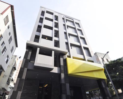 un edificio alto con una fachada amarilla y negra en 逢甲25行館Fengjia 25 Hotel, en Taichung