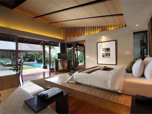 a bedroom with a large bed and a living room at Ametis Villa -Adult Only in Canggu