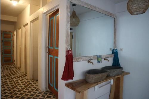 a bathroom with two sinks and a large mirror at Lala Salama Backpacker in Teluk Nara