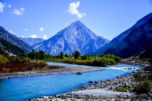 un fiume con una montagna sullo sfondo di Brown bear camping gurez a Kanzalwan
