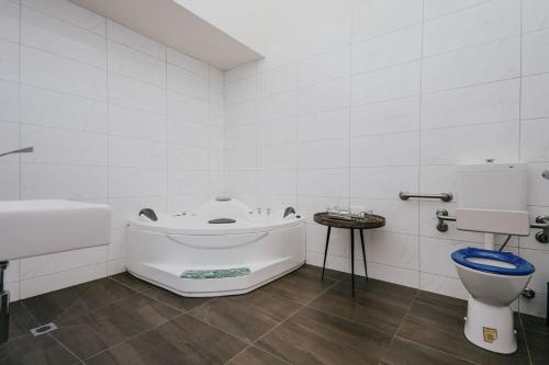 a white bathroom with a tub and a toilet at Albert Hotel Daylesford in Daylesford