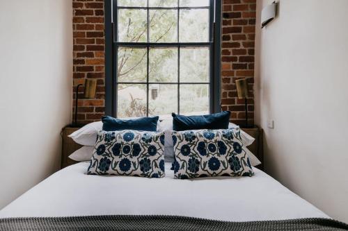 a bed with pillows in a room with a window at Albert Hotel Daylesford in Daylesford
