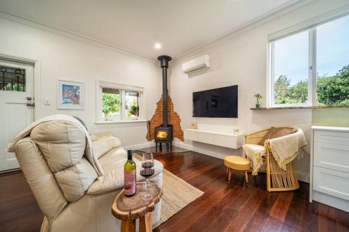 a living room with a couch and a fireplace at Laurant's Cottage ~ McLaren Vale entertainer in McLaren Vale