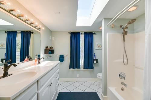 La salle de bains est pourvue d'un lavabo et d'une douche avec des rideaux bleus. dans l'établissement Pamlico River Vacation Rental with Game Room, à Bath