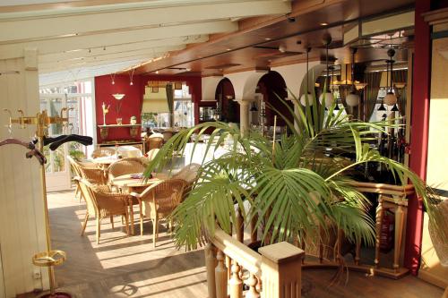 een eetkamer met tafels, stoelen en planten bij Hotel Hannover in Bad Nenndorf