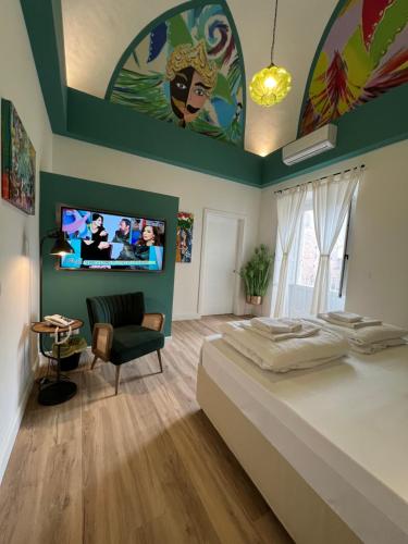 um quarto com uma cama grande e uma televisão de ecrã plano em Bibike em Catânia