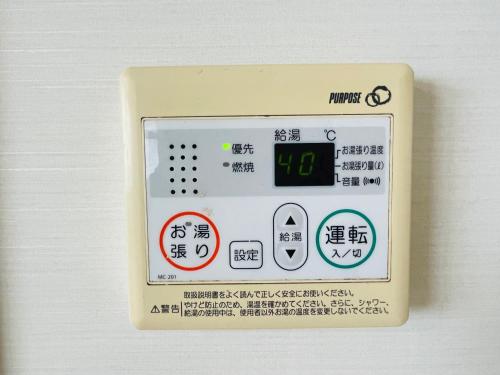 an electronic device with a clock on it at Uhome Kamogawa 本館-【ペット可/広い2LDK】 in Kamogawa