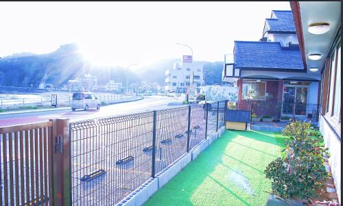 a car driving down a road next to a building at Uhome Kamogawa 本館-【ペット可/広い2LDK】 in Kamogawa