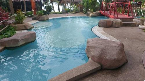 a swimming pool with rocks and a slide at Jazz Rainbow Paradise beachfront Peanag in Tanjung Bungah