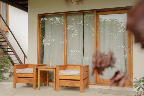 a wooden table and chairs in front of a window at Seascapes Bira in Bira