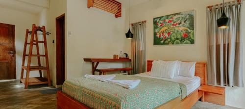 a bedroom with a bed and a painting on the wall at Seascapes Bira in Bira