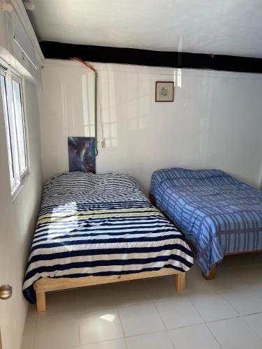 two beds in a small room with at Casa Nova! PRIVATE BATHROOM AND ROOM in Cancún