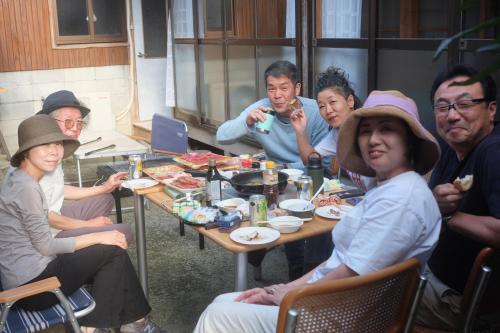 にある夕食プランあり 一棟貸し民宿 春名の食卓に座って食べる人々