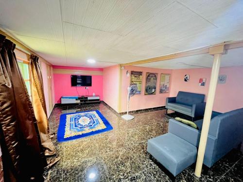 a living room with a couch and a tv at Halim's Rumah Singgah Mxslim only in Jelutong