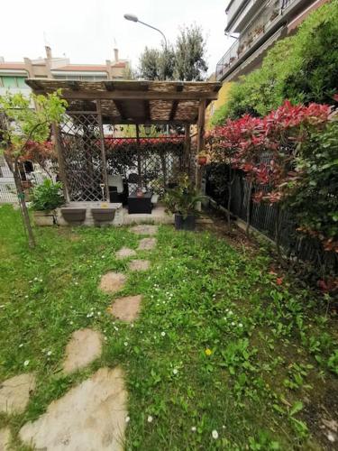 a garden with a wooden pergola and some plants at La Gabbianella in Marcelli