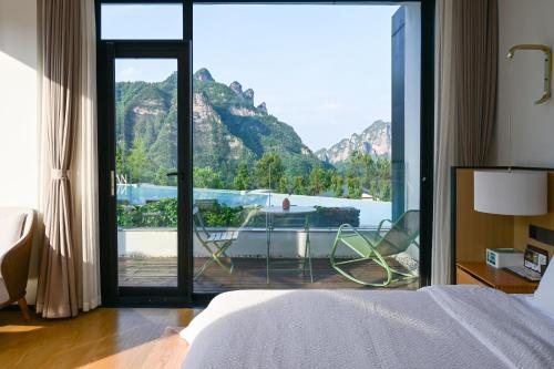 a bedroom with a large window with a view of a boat at XMAN Sunrise Peaks Resort--Free Pick-up in Zhangjiajie