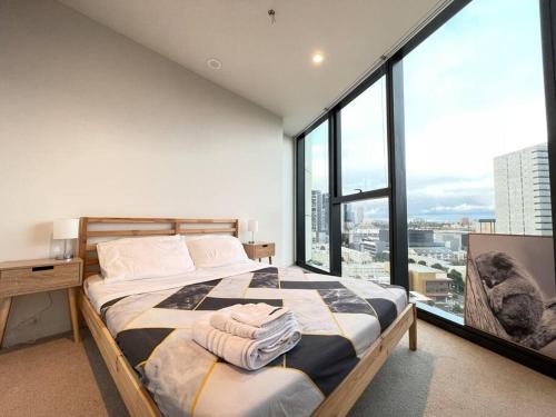 a bedroom with a bed and a large window at City View Luxury 3 Bedroom Apartment-Free Car Park in Melbourne